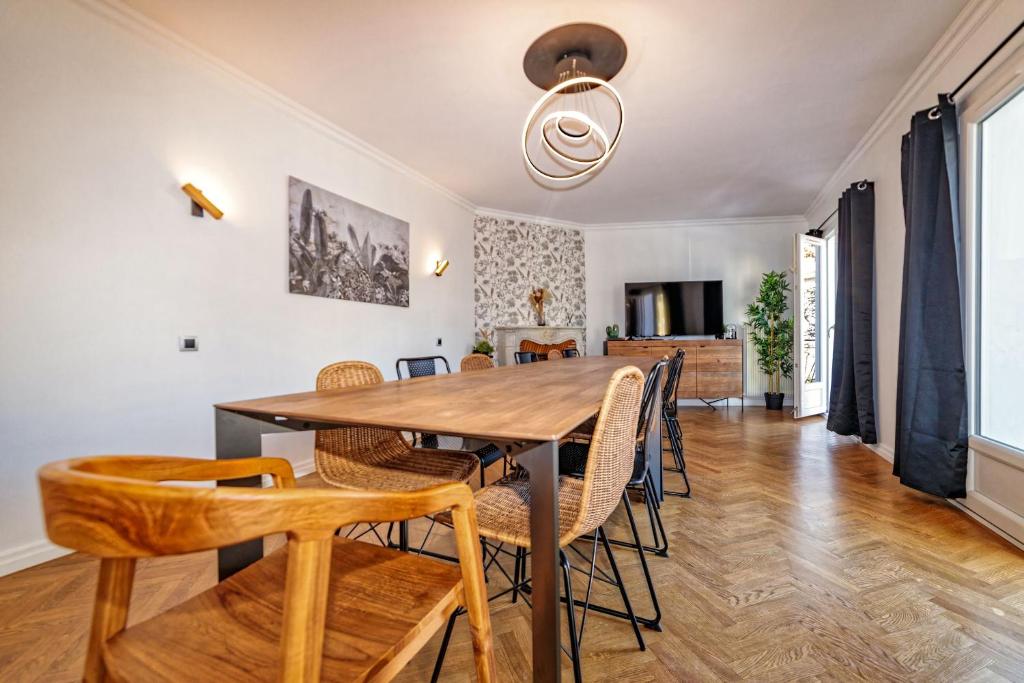克莱蒙费朗Maison 15 couchages idéale pour séjour en groupe的一间带木桌和椅子的用餐室