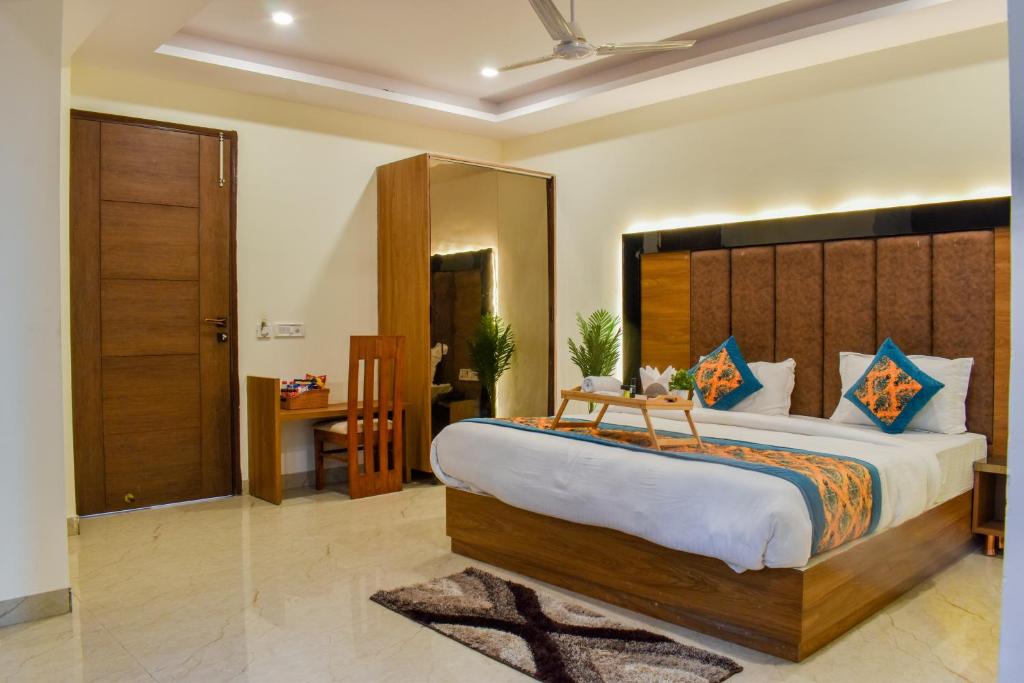 新德里HOTEL YASH PALACE的一间卧室配有一张大床和木制床头板