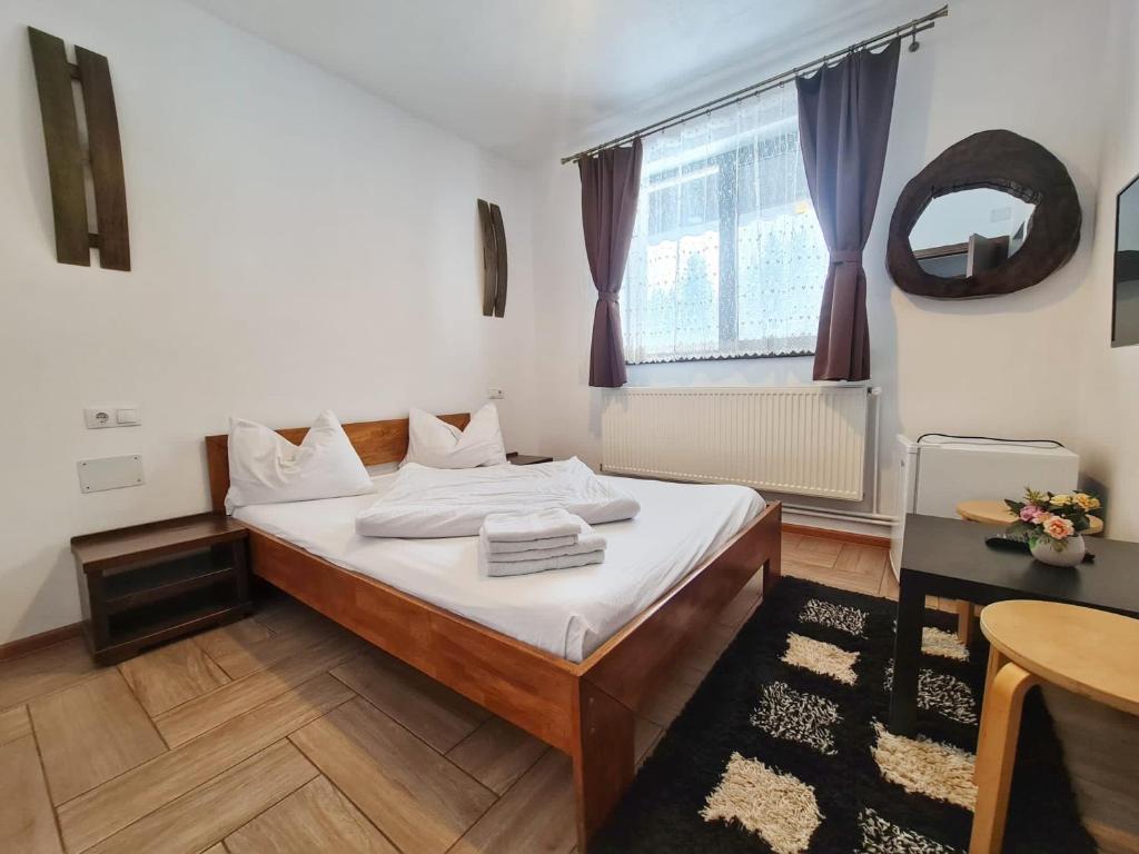 NucetCABANA FRAM VÂRTOP的一间卧室配有一张床、一张桌子和一个窗户。