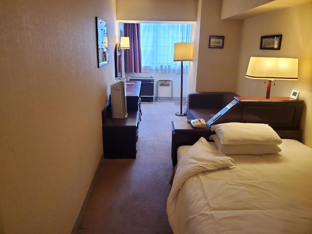 东京泽姆城市旅馆的酒店客房,配有床和电视