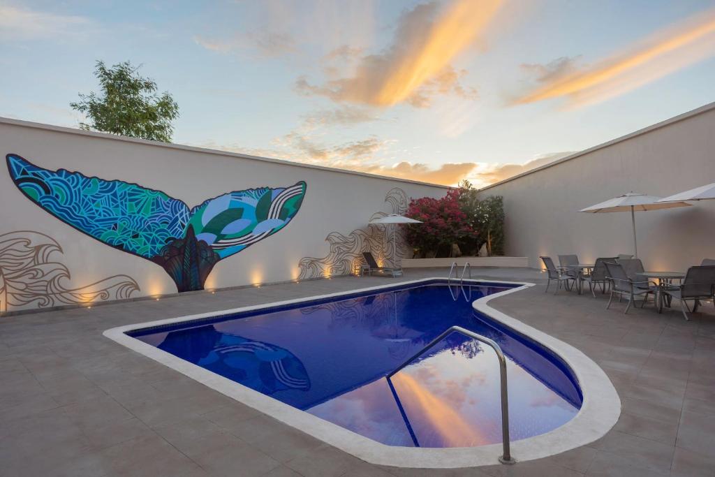 卡波圣卢卡斯Fairfield by Marriott Los Cabos的一座建筑的一侧,设有一座带壁画的游泳池