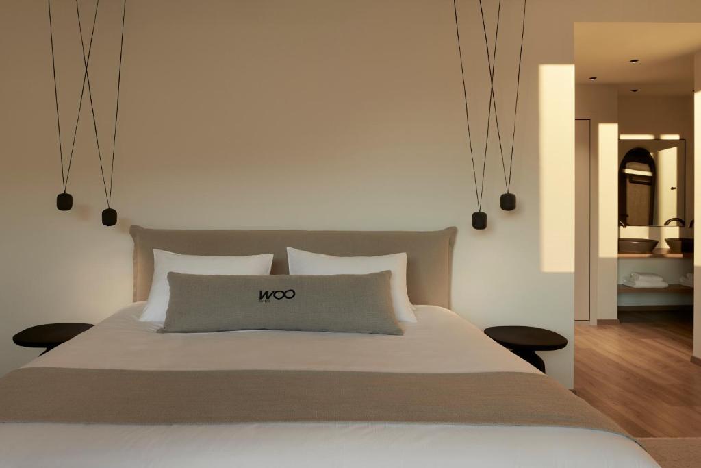 雅典Athens Woo Suites的一间卧室,配有一张大床,上面有小号标志