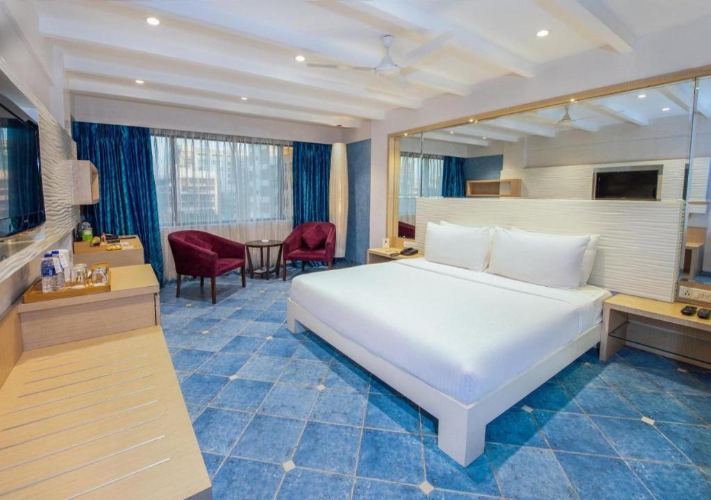 新德里Ocean Suites Near Delhi International Airport的卧室配有一张白色的大床和一张桌子