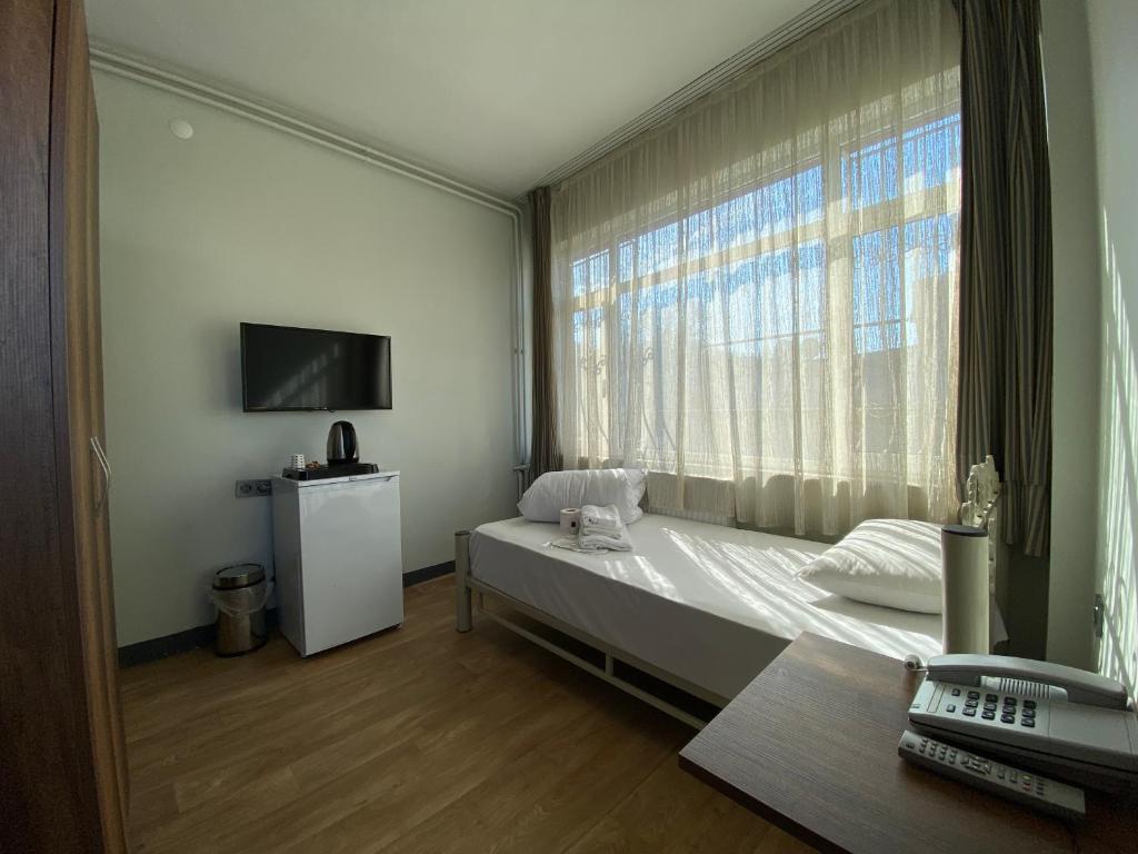 伊斯坦布尔Ferah Otel的一间卧室设有一张床和一个大窗户
