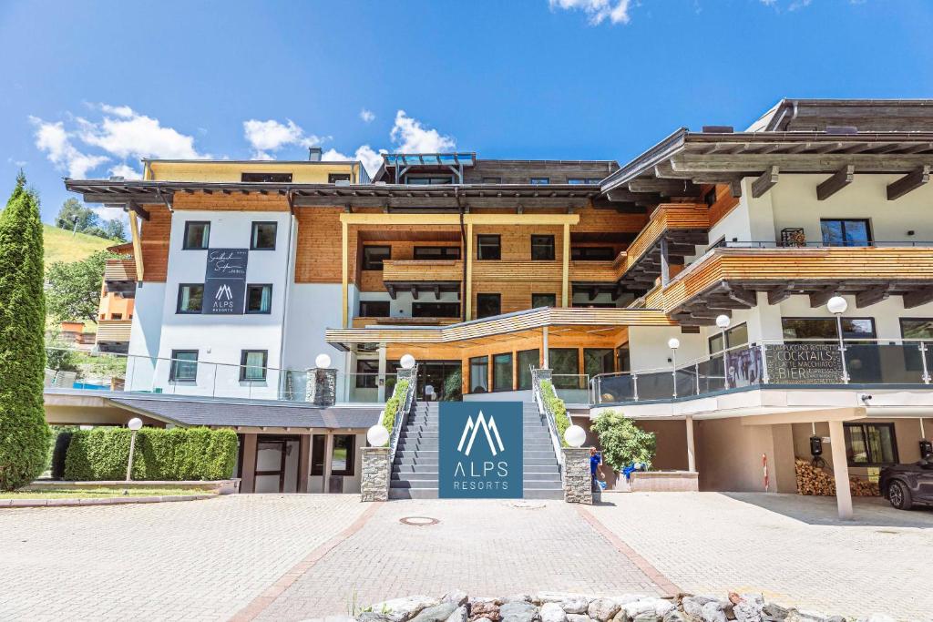 萨尔巴赫Saalbach Suites by ALPS RESORTS的前面有标志的大建筑