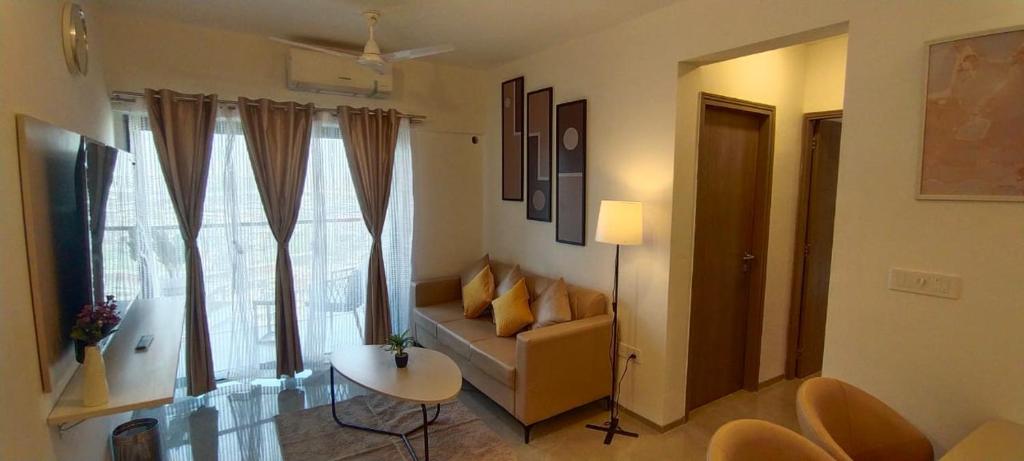 孟买Z Bliss Suites, BKC的带沙发、桌子和窗户的客厅