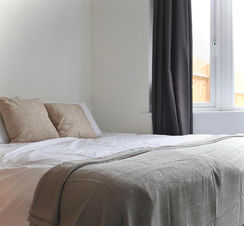 圣奥尔本斯Alban Suites的一张带两个枕头的白色床和窗户