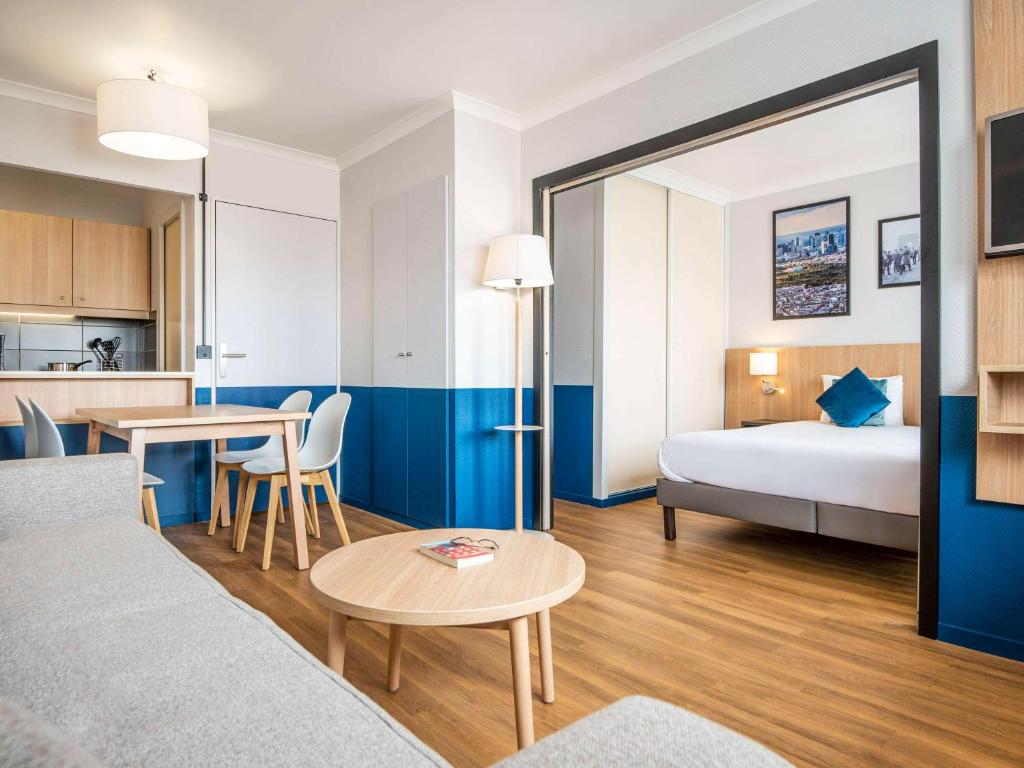 库尔布瓦拉德芳斯克莱贝尔爱达格公寓式酒店的酒店客房配有一张床铺和一张桌子。