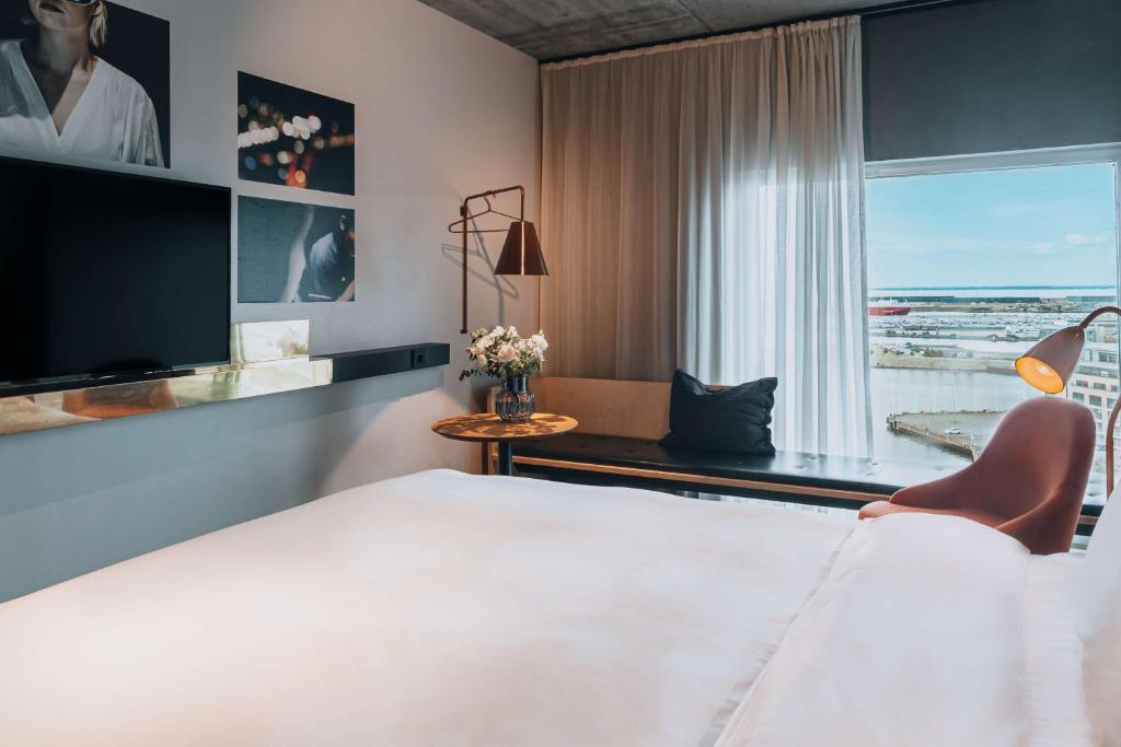 马尔默Story Hotel Studio Malmo, part of JdV by Hyatt的酒店客房设有一张床和一个大窗户