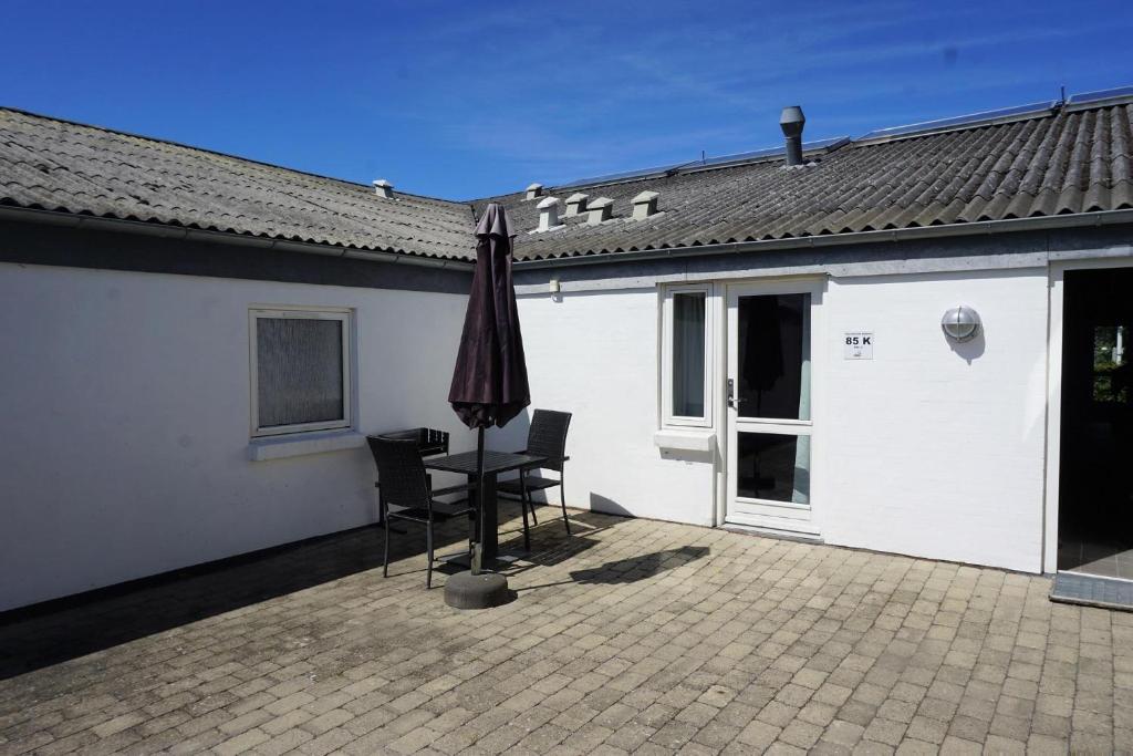 凯特明讷Kerteminde Byferie - Hyrdevej 83, 85K的庭院配有遮阳伞和桌椅。