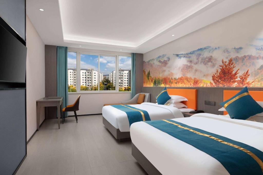 昆明昆明空港经济区戴斯精选温德姆酒店的酒店客房设有两张床和窗户。