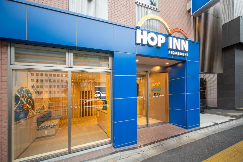 东京Hop Inn Tokyo Iidabashi的商店前方,上面有跳跃旅馆标志