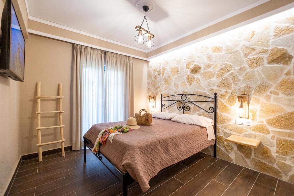 古维亚Mathraki Resort的一间卧室配有一张石墙床