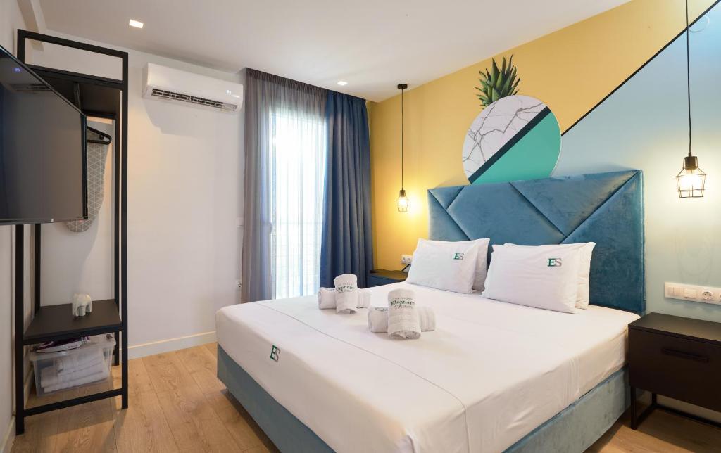 塞萨洛尼基Urban Elephant Suites的一间卧室配有一张大床和蓝色床头板