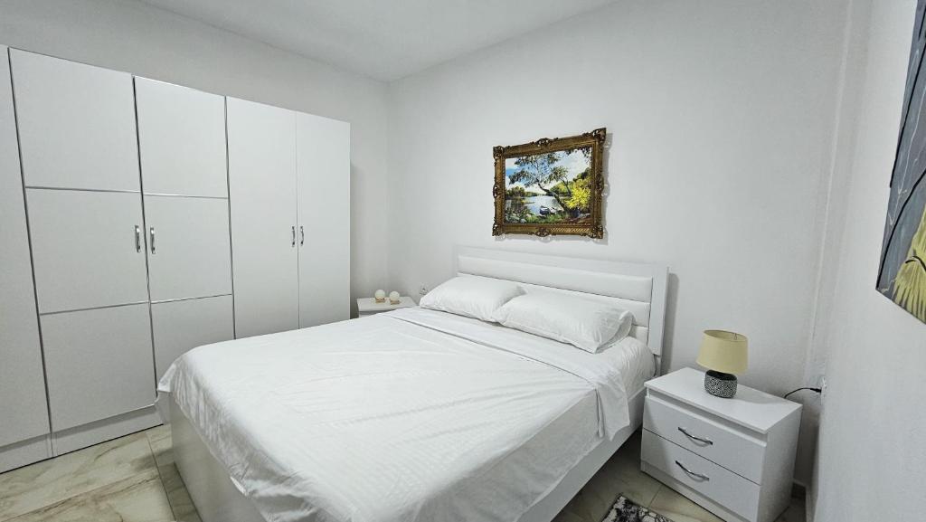 培拉特Guesthouse Albi的白色的卧室配有一张床,墙上挂着一幅画