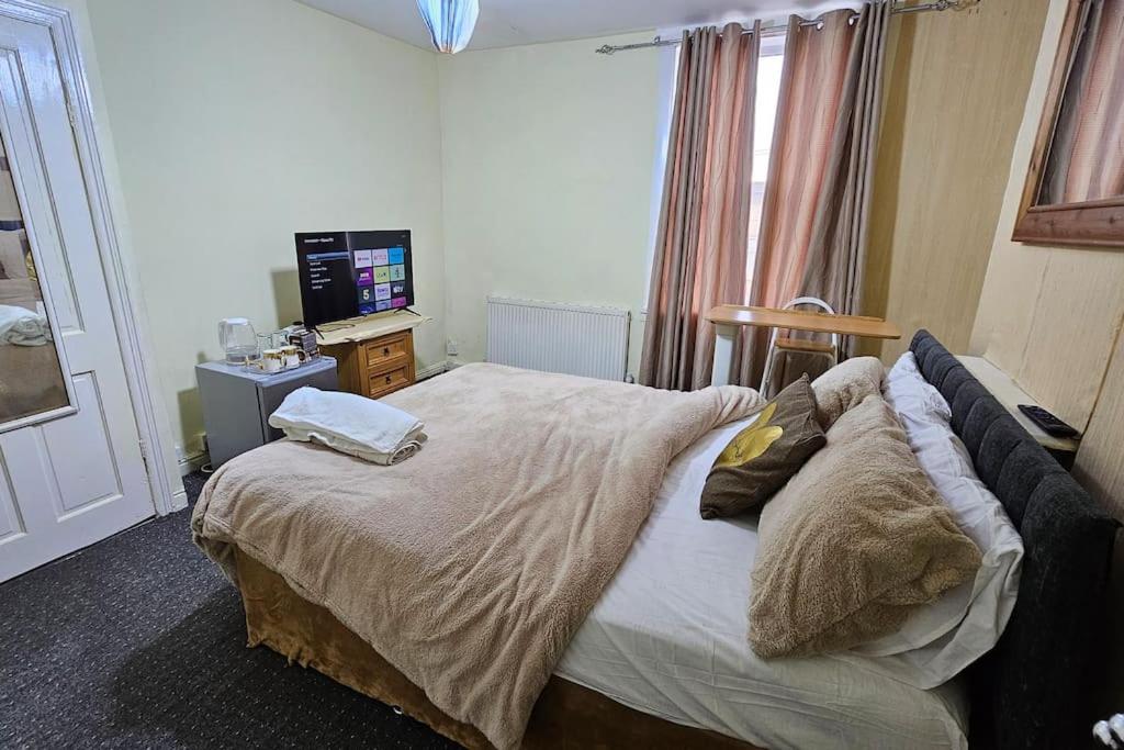 利兹Affordable Private Space的一间卧室配有一张大床和电视