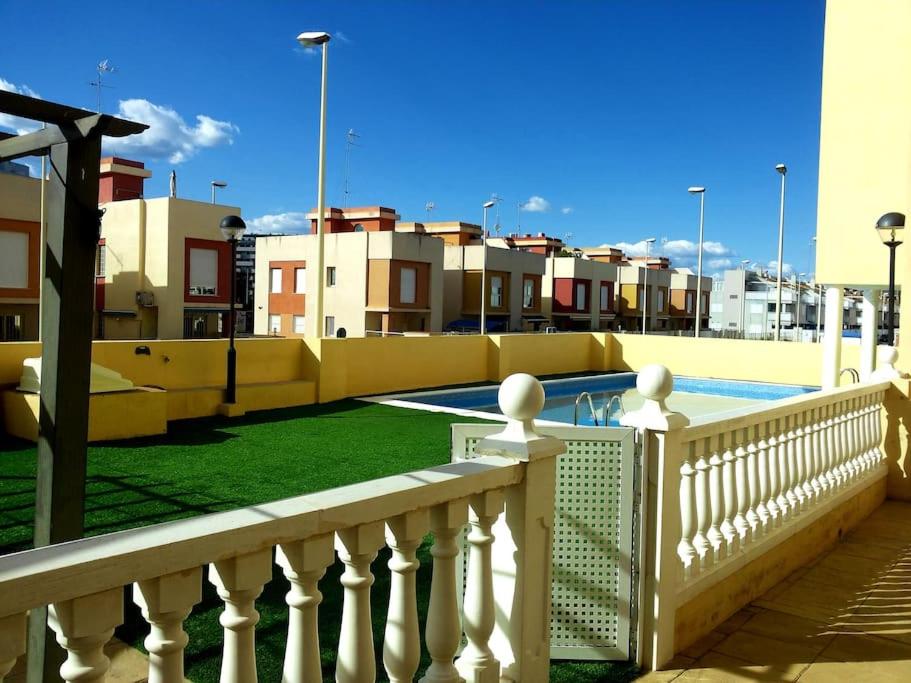 蒙科法尔Apartamento con piscina a pocos metros de la playa的一个带围栏和游泳池的阳台