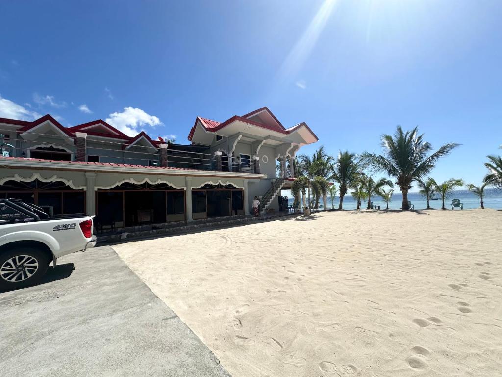 圣胡安Lawson’s Beach Resort的停在海滩上房子前面的一辆白色卡车