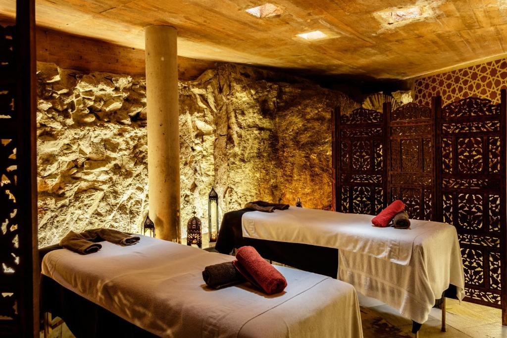 托莱多水边精品酒店的一间设有两张床和石墙的房间