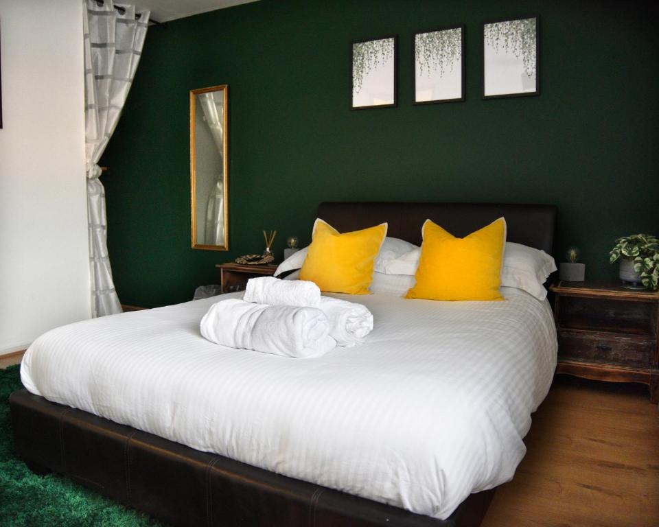 拉夫堡Hermitage, 3 Bed entire House in Loughborough的一间卧室配有一张带黄色枕头的大床
