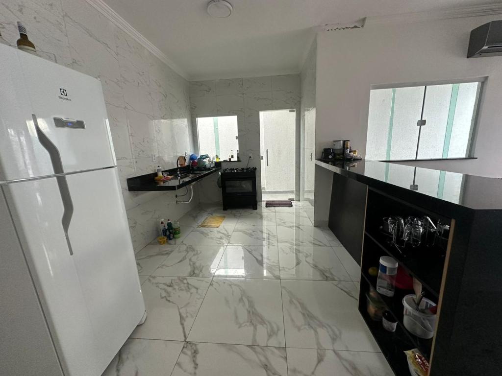 卡波布里奥Casa 02 Almeida的厨房铺有白色大理石地板,配有冰箱。