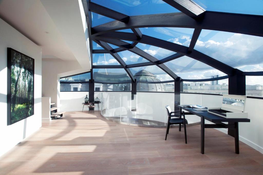 布鲁塞尔Triplex penthouse in the city center的客房设有桌椅和大窗户。