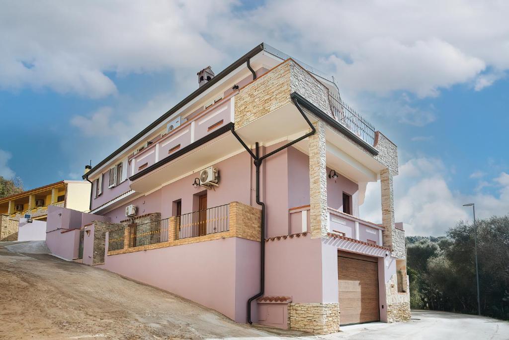 贡内萨Sardinia's house IUN R5500的土路上的粉红色房子