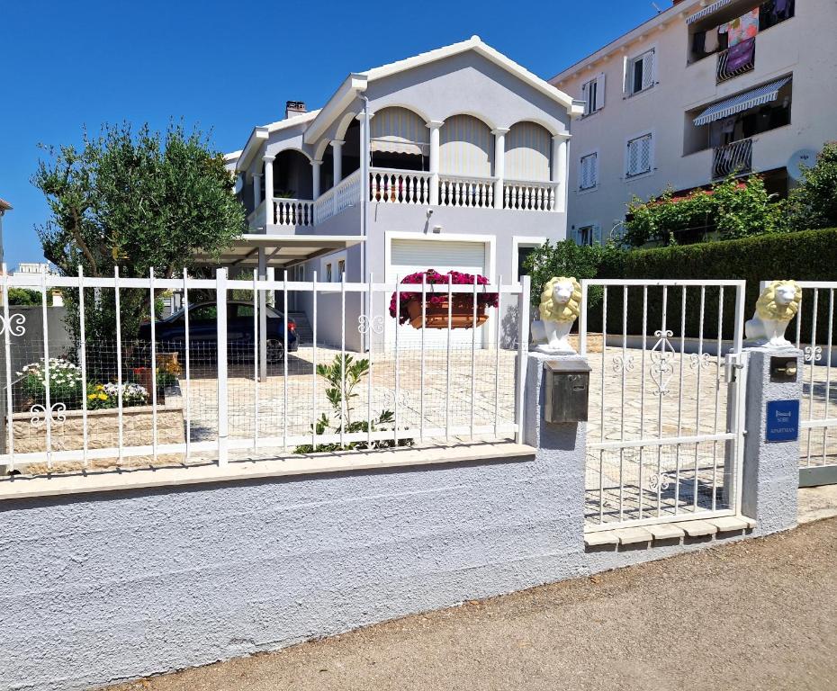 扎达尔Cosy villa near the beach的建筑前的白色围栏