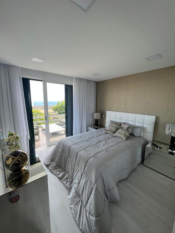丰沙尔Apartamento Belo Horizonte的一间卧室设有一张大床和一个大窗户