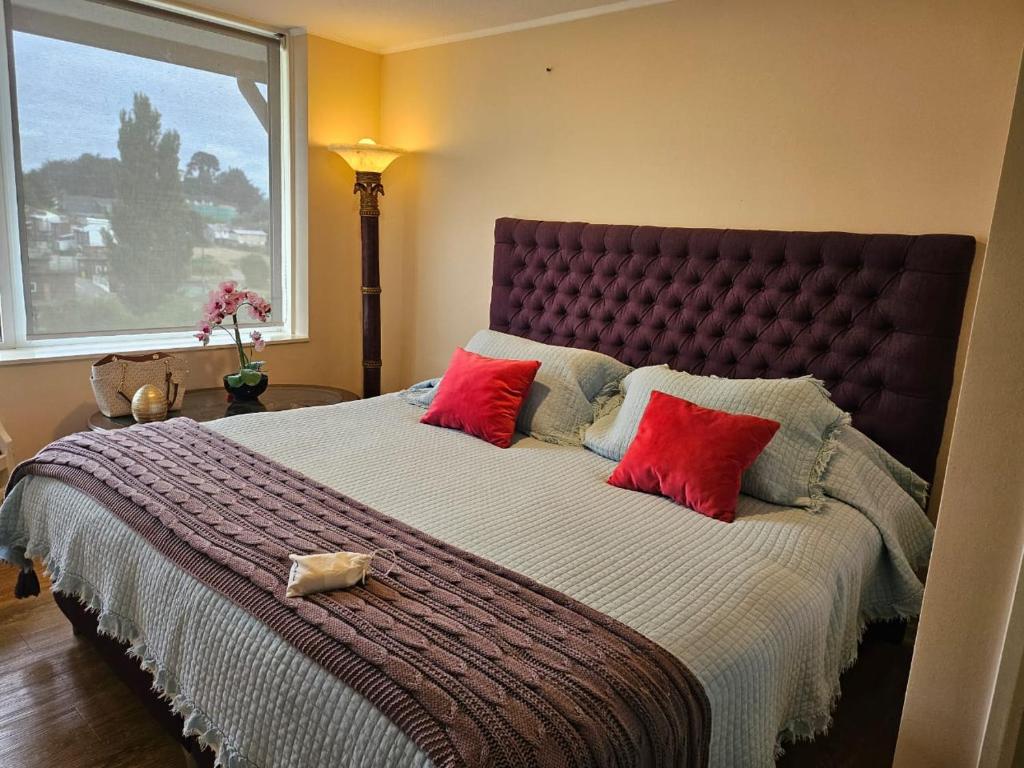 巴拉斯港Departamento a minutos del Lago的一间卧室配有一张带红色枕头的大床