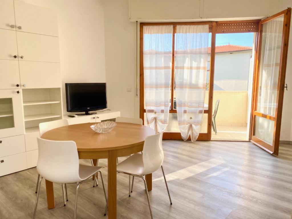 圣温琴佐Appartamento Elisa的一间带桌椅和电视的用餐室