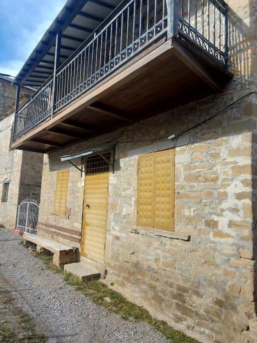 达尔德赫Vila Ceku的带阳台的砖砌建筑和黄色的门