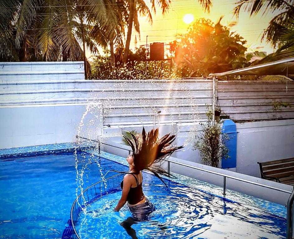 瓦加托Mitra Hostel (By The Pool)的女人在喷泉泳池游泳