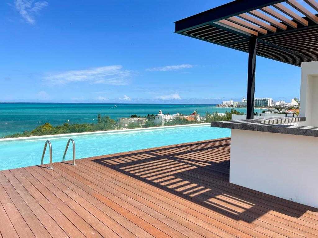 坎昆2BR Oceanfront Luxury Apartment in the Hotel Zone的海景甲板上的游泳池