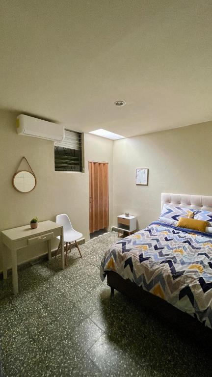 圣萨尔瓦多Lindo espacio, cómodo y céntrico的一间卧室配有一张床、一张桌子和一张书桌
