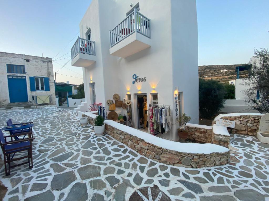 佐努萨岛Theros Apartments Donoussa的白色的建筑,设有石头庭院和商店