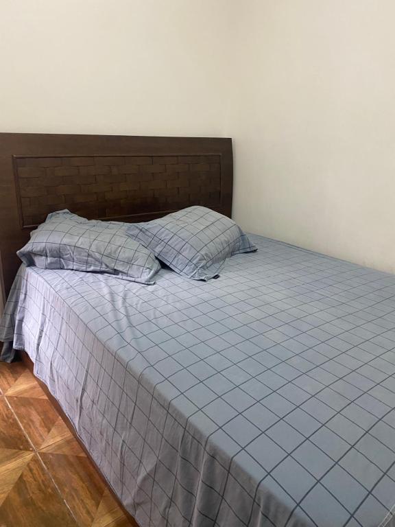 圣保罗Edículas da vivi的一张带蓝色棉被和两个枕头的床