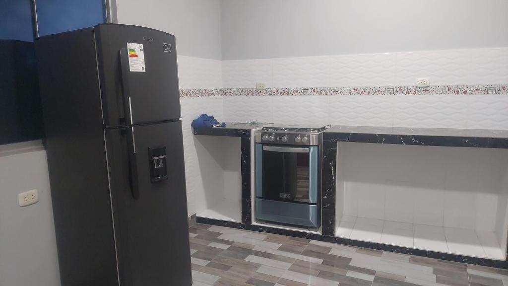 伊基托斯Casa Alojamiento Picuro Lodgind的一间厨房,里面配有黑色冰箱