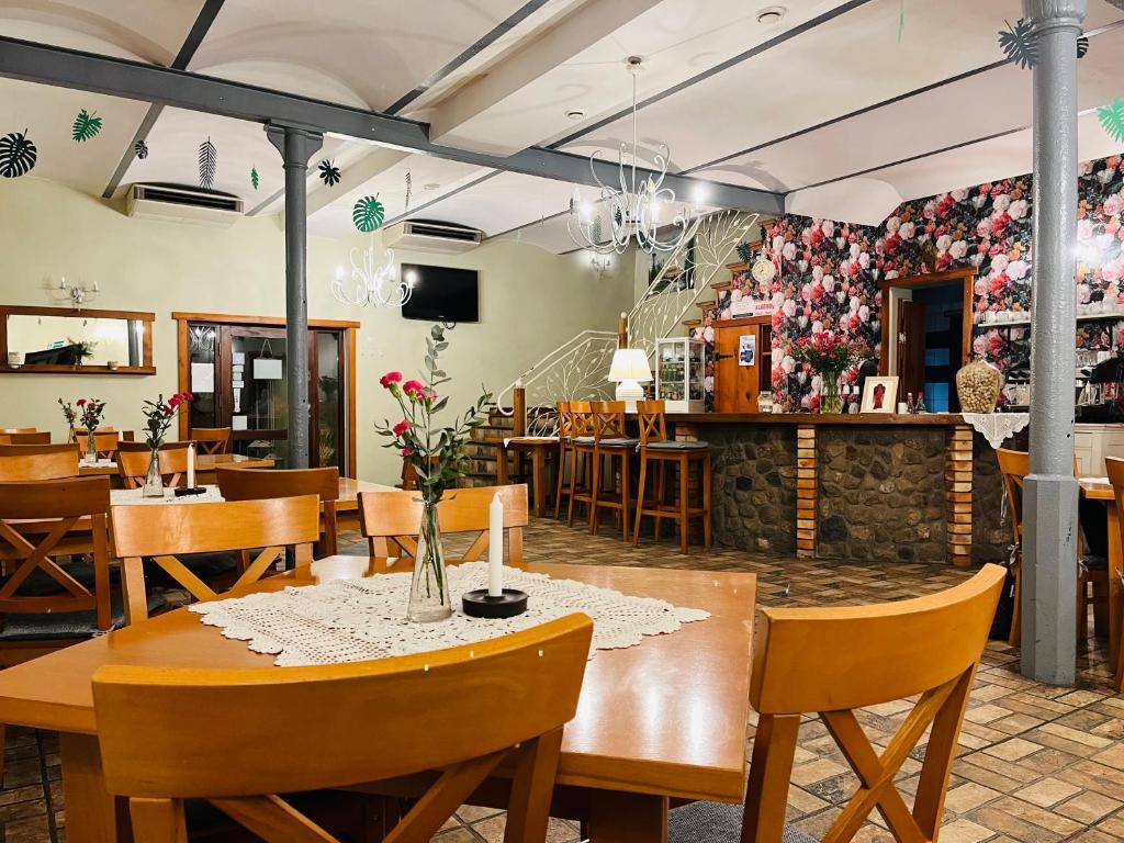 波别济斯卡马奇约娃查塔乡村民宿的餐厅墙上挂着木桌、椅子和鲜花
