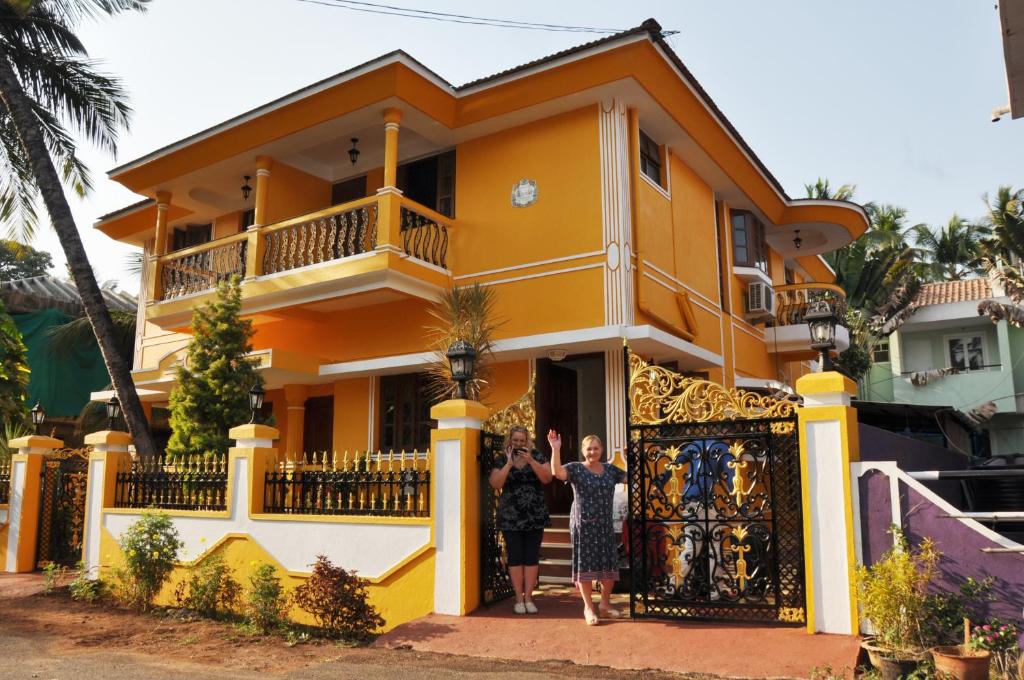 比纳里姆敏瑞雅旅馆的两个人站在一个黄色房子前面