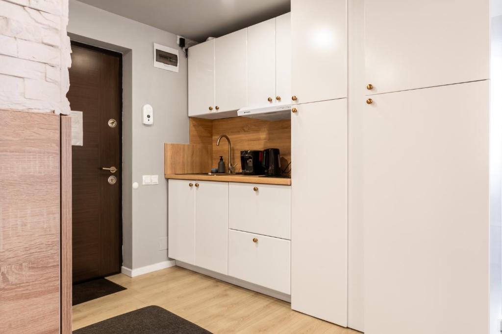 克卢日-纳波卡Romantic Jacuzzi Studio的厨房配有白色橱柜和水槽