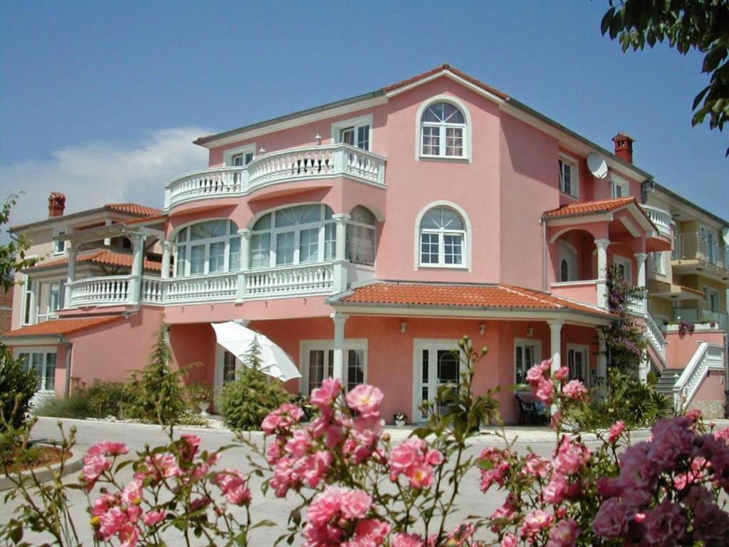 法扎纳Hotel Villa Vera 2的粉红色的房子,花朵粉红色