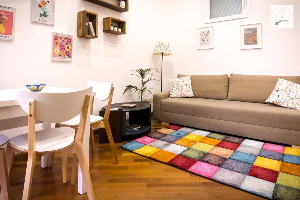 卡塔尼亚Gli Appartamenti al Duomo的客厅配有沙发和色彩缤纷的地毯