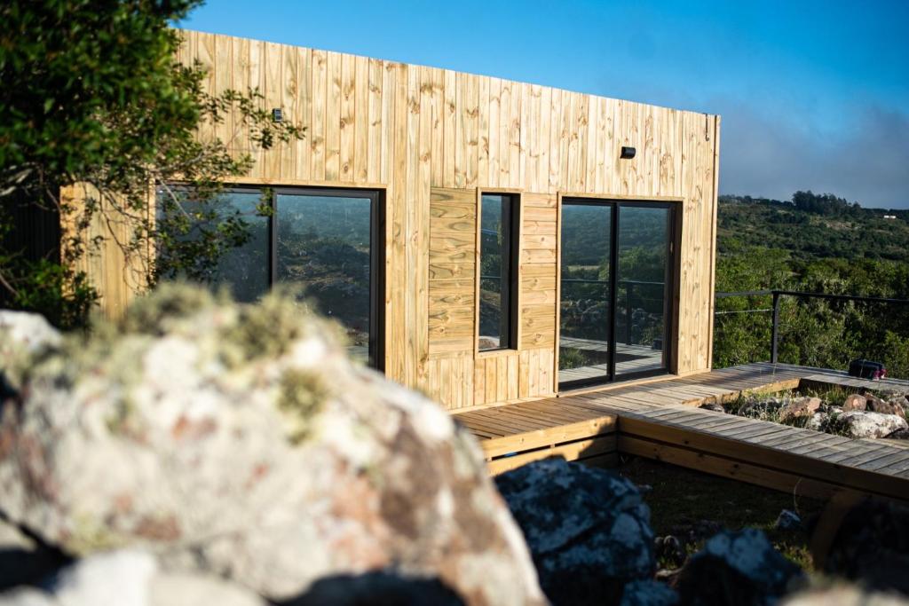 塞拉纳镇El Secreto en las Sierras的木屋设有甲板和窗户