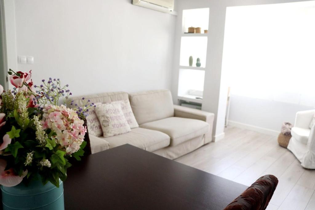 格拉纳达La morada del viajero的客厅配有沙发和鲜花桌