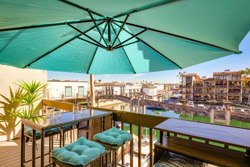 长滩Waterfront Long Beach Condo with Pool Access!的一个带桌椅和遮阳伞的庭院