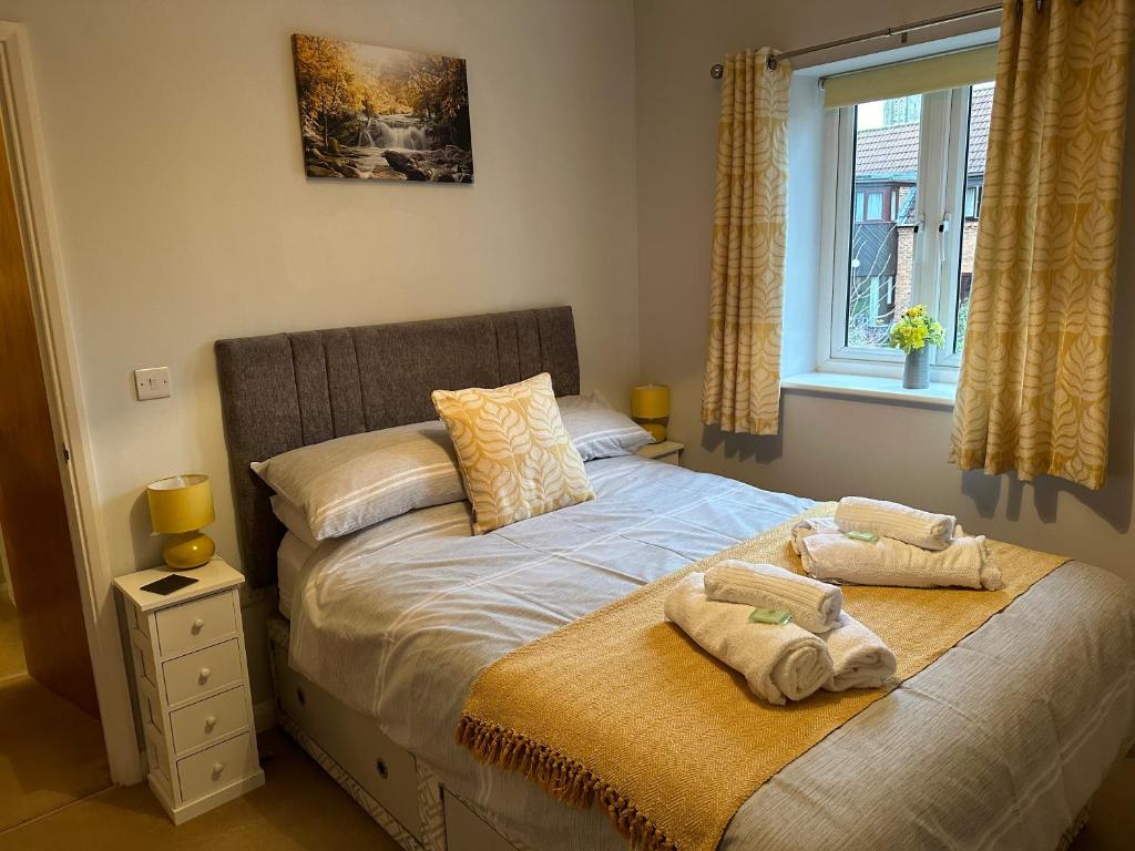 格拉斯顿伯里Abbotsleigh Rest - close to Glastonbury Abbey的一间卧室配有一张床,上面有两条毛巾