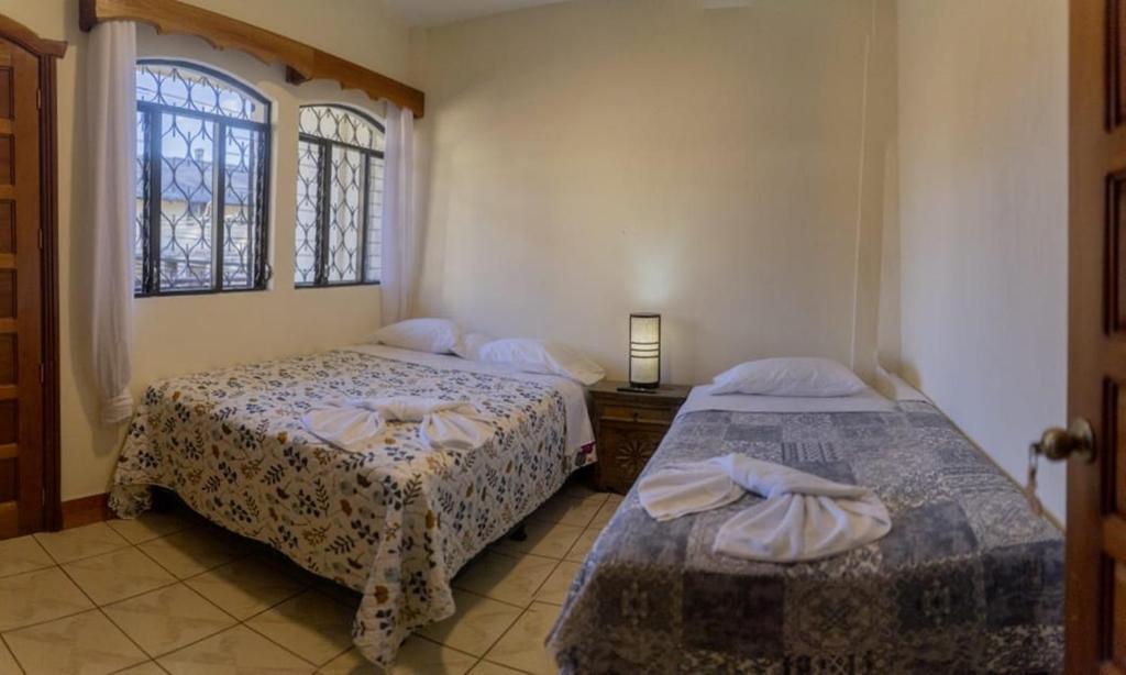 帕纳哈切尔Hotel Los Manantiales的一间卧室设有两张床和窗户。