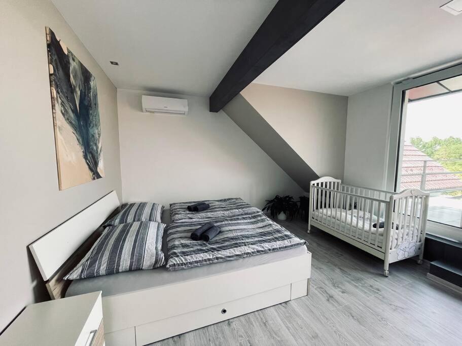 米库洛夫Apartmán U Trati的一间带一张床和一张婴儿床的小卧室