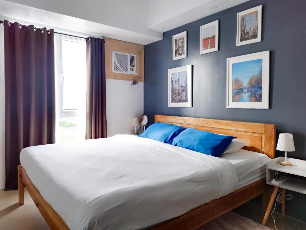 伊洛伊洛Modern Oasis*Heart of City*Fast Wi-Fi/Netflix WFH的一间卧室配有一张带蓝色墙壁的大床